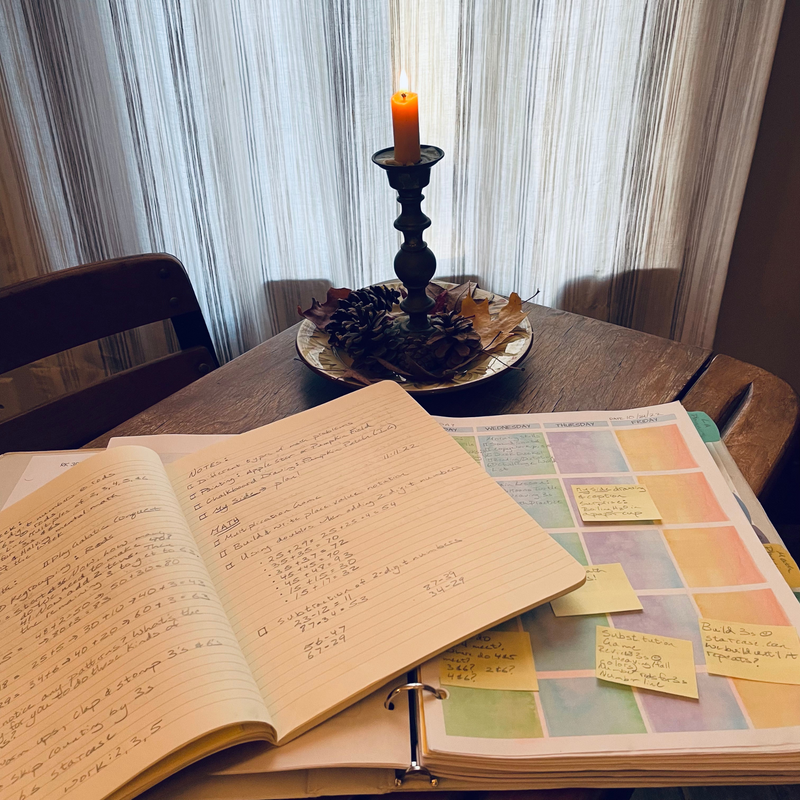 This is an image of homeschool planning by candlelight using the Holistic Planning Pack Templates for homeschoolers.