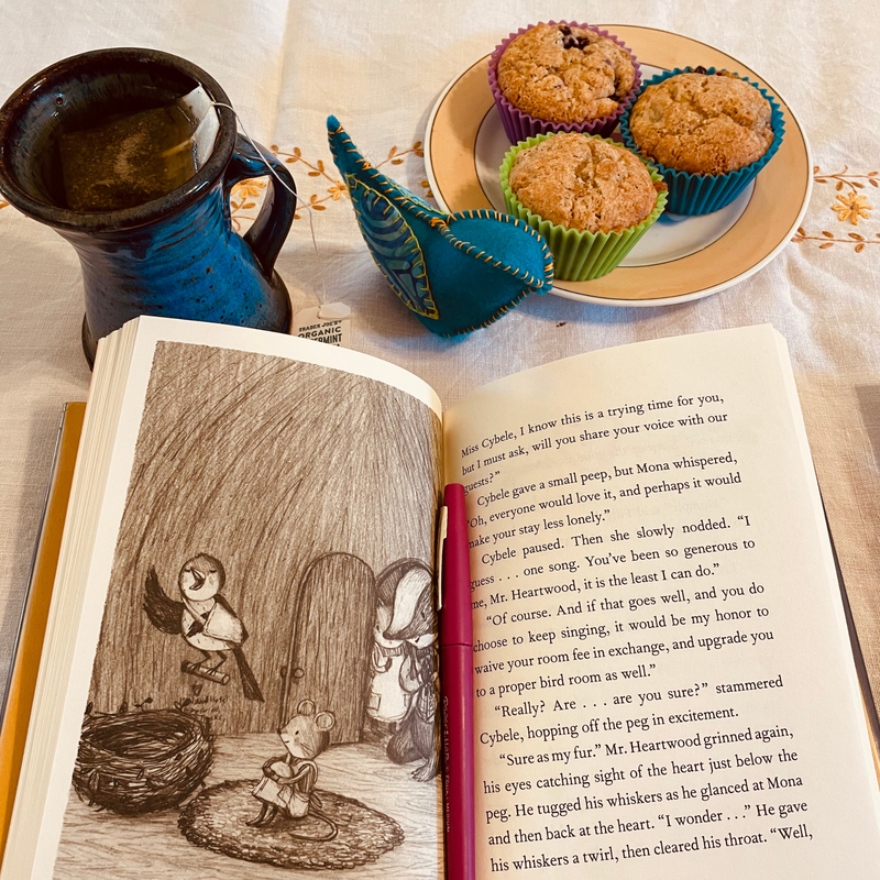 This is an image of the book Heartwood Hotel with muffins and tea on a table from the Heartwood Hotel Book Hearth Guide for homeschoolers.